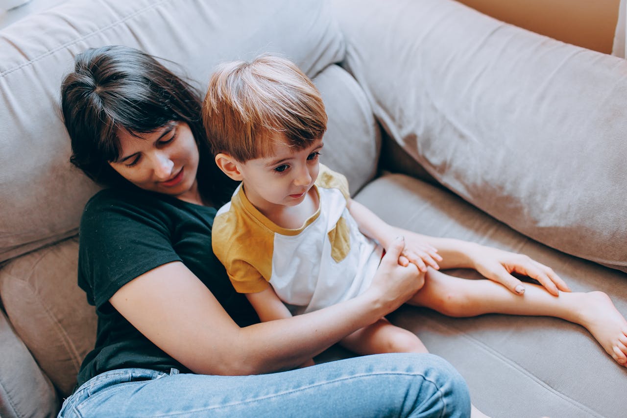 gallery-2 A mother and her young son relaxing on a comfortable sofa, sharing a tranquil bonding moment.
