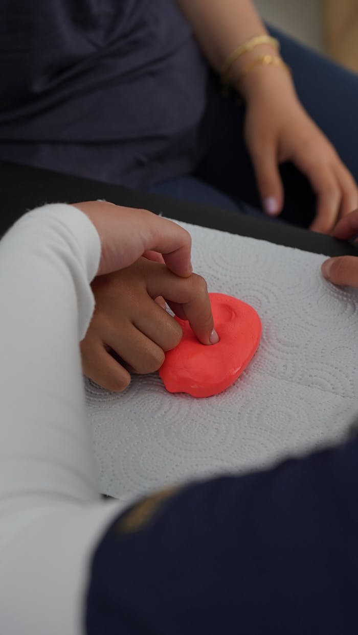 about-01 Close-up of hands manipulating putty during therapy session, emphasizing motor skills.