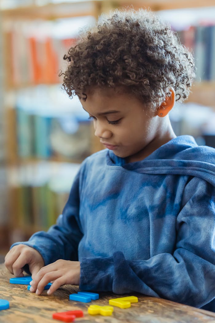 services-img A young boy in a cozy indoor setting engaged in a puzzle game, promoting creativity and concentration.