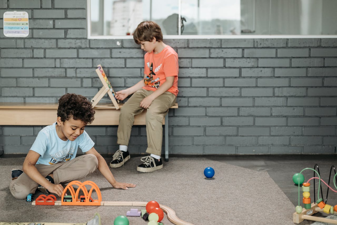 gallery-3 Two boys engaged with educational toys in a kindergarten classroom setting.